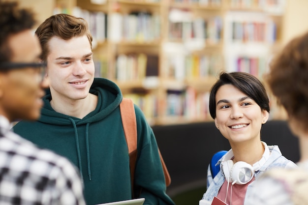 Positive Schüler unterhalten sich in der Bibliothek