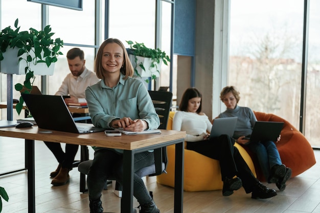 Positive und fröhliche Stimmung Die Leute arbeiten im Büro mit Bohnenbeuteln und Stühlen darin