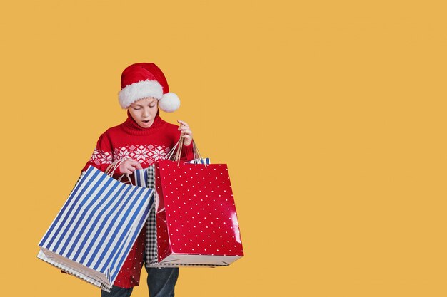 Positiver Junge in Sankt-Hut mit Geschenken