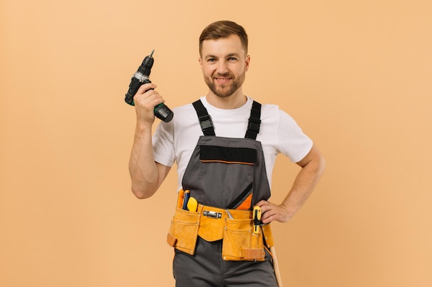 Positiver männlicher Handwerker zu Hause mit Schraubendreher auf beigem Hintergrund