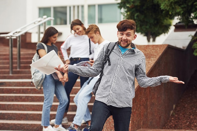 Positiver Typ. Gruppe junger Studenten in Freizeitkleidung tagsüber in der Nähe der Universität.