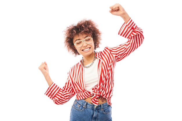 Positives glückliches kasachisches Mädchen mit lachender Afro-Frisur freut sich, den Sieg zu feiern, hörte gute Nachrichten isoliert auf weißem Hintergrund