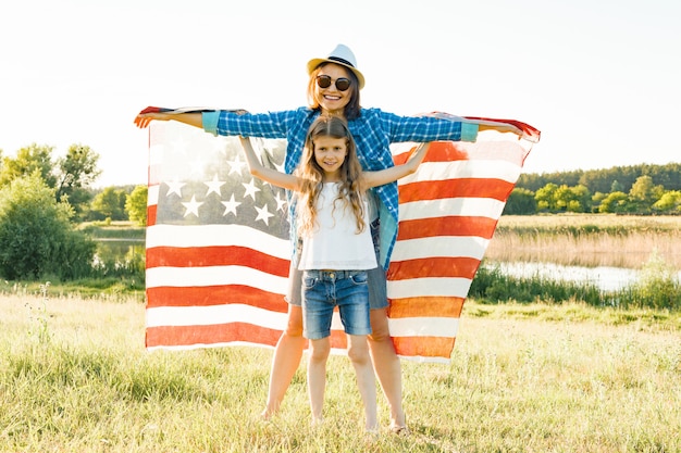 Positives Porträt der Mutter und der Tochter mit amerikanischer Flagge