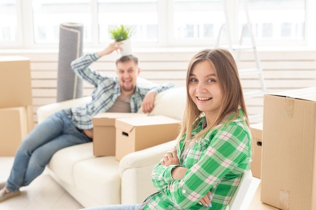 Positivo niña sonriente sentada contra su marido riendo borrosa en una nueva sala de estar mientras