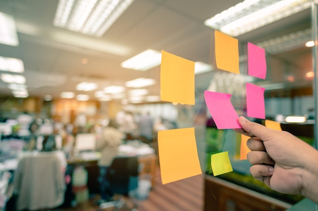 Foto post-it colorido colado em glassed tem espaço de cópia para colocar texto para lista e mão