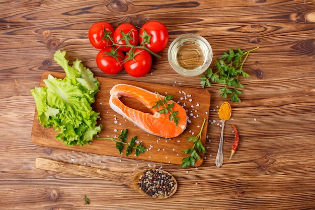 Posta de salmão com legumes e especiarias em um espaço de madeira. O conceito de cozinhar. Espaço de supermercado.