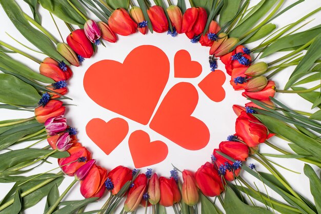 Postal para el día de la familia un marco floral de tulipanes y una semilla de corazones