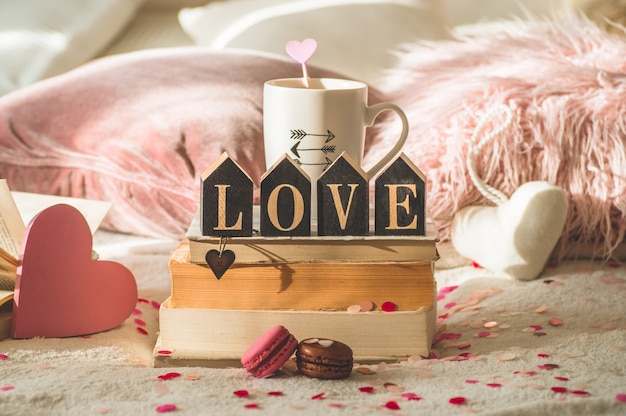 Postal feliz día de San Valentín. Concepto de amor para el día de la madre y el día de San Valentín. Corazones y libros con taza de café. Tarjeta de San Valentín con espacio para texto