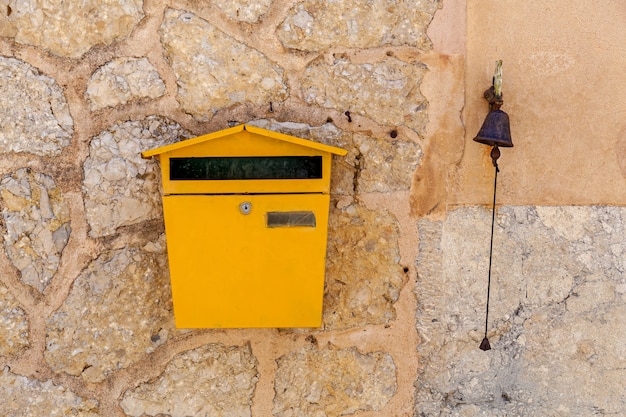 Postbox e um sino em uma parede de pedra, Postbox e um sino