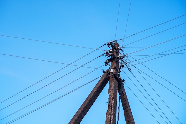 Poste con alambres contra el cielo.