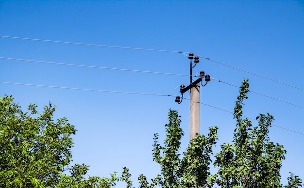 Poste de apoio elétrico com elementos de cerâmica contra fundo de céu azul