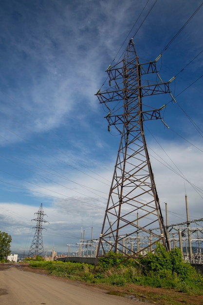 Poste de energia com fios contra o céu azul Produção e transporte de eletricidade