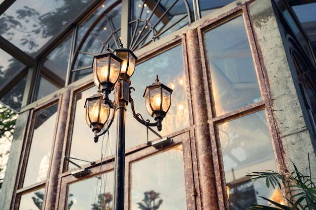 Poste de lâmpada retrô brilhando na porta vintage na cidade