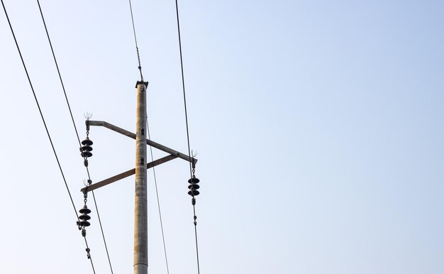 Poste de transmissão de eletricidade fechado sob o céu nebuloso com espaço de cópia