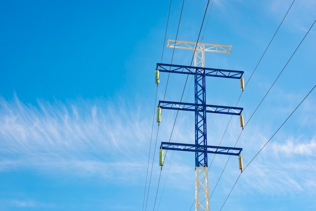 un poste eléctrico de alta tensión contra el cielo azul y las nubes