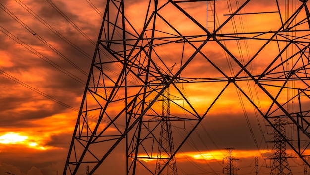 Foto poste eléctrico de alto voltaje y líneas de transmisión en la noche.