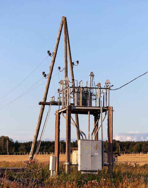 Poste eléctrico junto a la carretera con transformadores y cables de línea eléctrica.