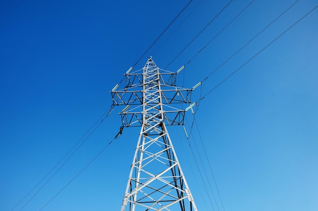 Poste eléctrico sobre cielo azul, torre de alto voltaje