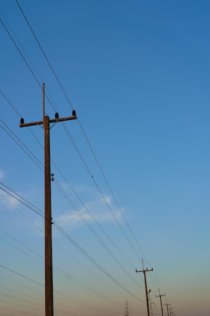 Un poste de energía con un cielo azul de fondo.