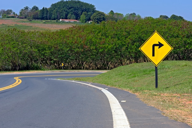 Poste indicador de curva derecha aguda en carretera