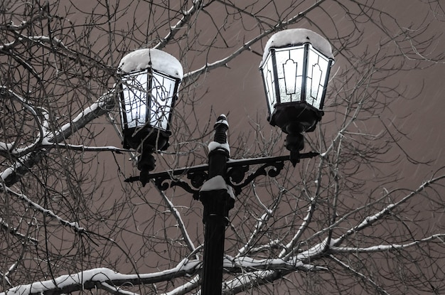 Un poste con linternas encendidas en una noche de invierno.