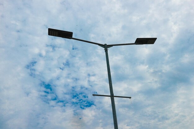 Foto el poste de la luz de la calle se disparó de cerca con el cielo azul con nubes blancas en el fondo