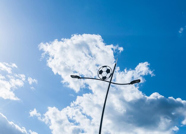 Poste de luz en forma de bola contra el cielo azul con nubes