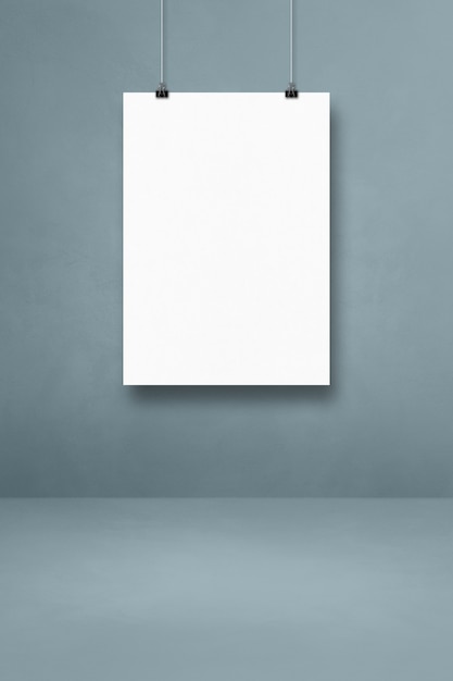 Pôster branco pendurado em uma parede cinza com clipes. Modelo de maquete em branco
