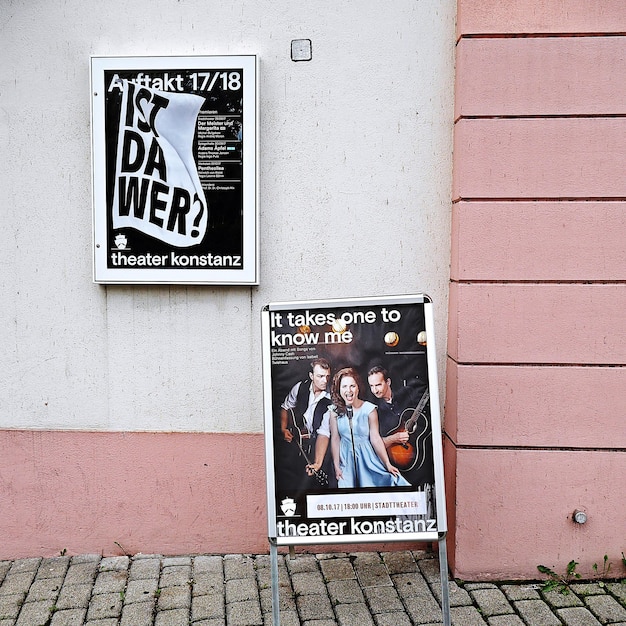 Foto poster eines musikveranstaltungs auf dem fußweg gegen ein gebäude