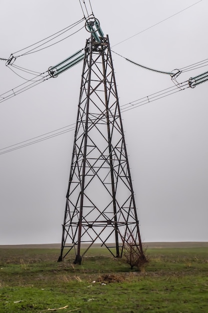 Postes de cable eléctrico de metal usados en el campo durante el tiempo lluvioso