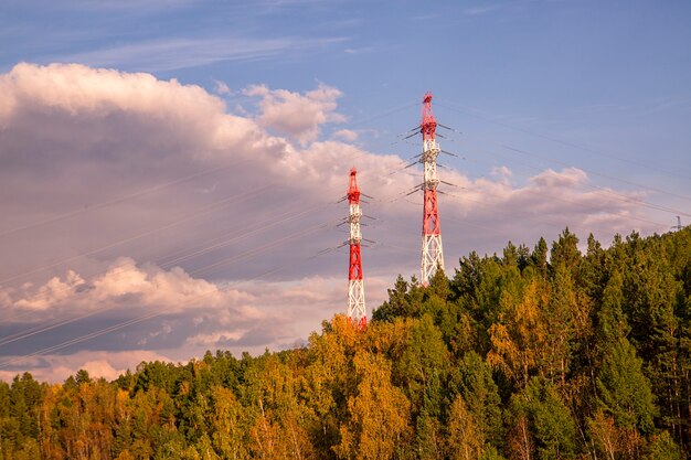 Postes de linhas de alta tensão nas montanhas da margem do rio Produção e transmissão de eletricidade