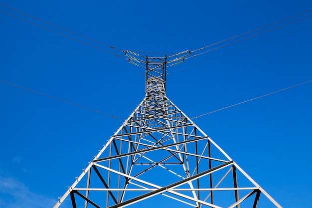 Postes eléctricos de alto voltaje fotografiados en primer plano ubicados en el campo