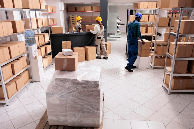 Postlagermitarbeiter, die die Paketzustellung verwalten, Kartons tragen und verpacken. Mitarbeiter der Logistikabteilung bereiten die Fracht für die Verteilung im Industrielager vor