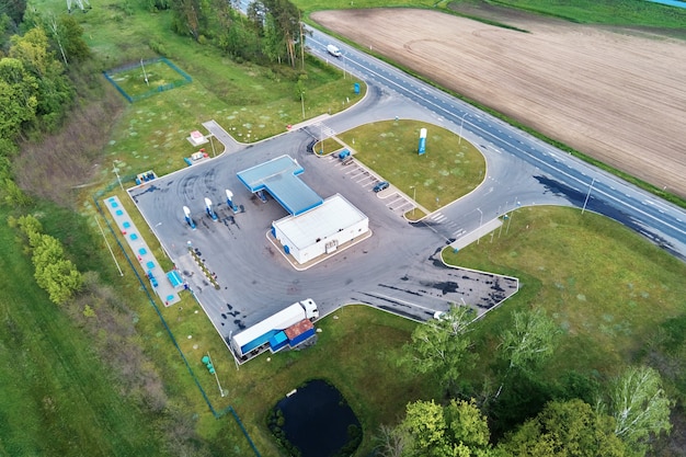 Posto de gasolina perto da rodovia com vista aérea de carros em movimento