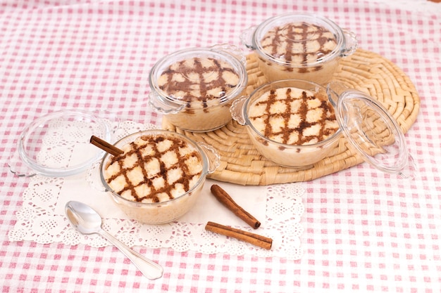 Postre de arroz dulce tradicional portugués sobre una mesa con canela en rama.