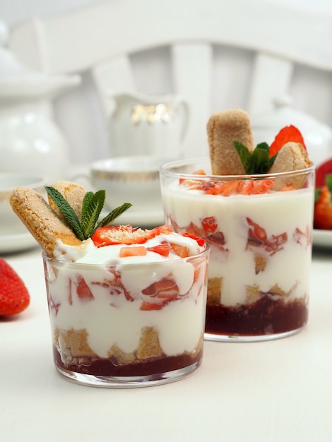 Postre de bayas en un vaso con galleta de fresa fresca y crema batida