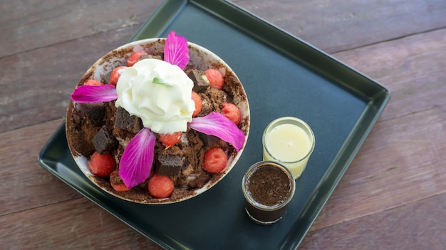 Postre de Bingsu del brownie y de la sandía en una tabla de madera.