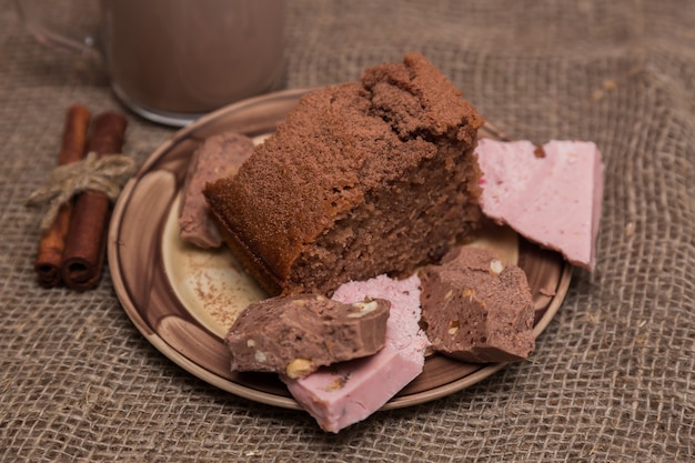 Postre. Bizcocho de chocolate con crema, canela y bayas. Pastel dulce de cacao y chocolate.