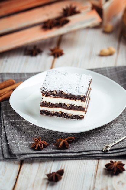 Postre de brownie con tortas de chocolate con nueces en la madera blanca