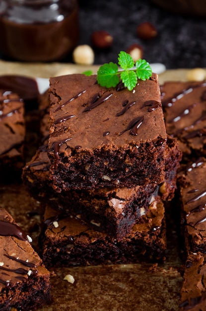 Postre casero de brownie de chocolate con avellanas, glaseado de chocolate y crema batida