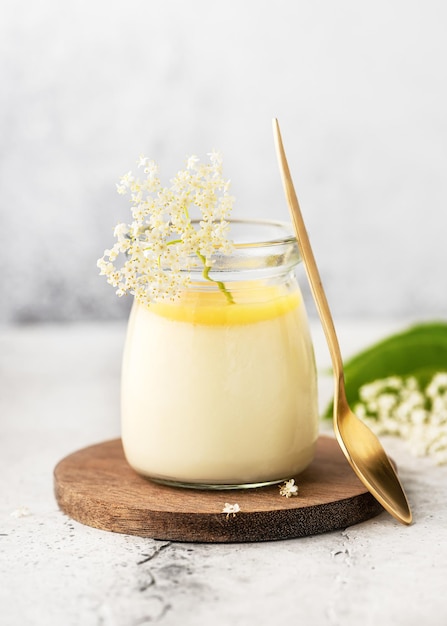 Postre casero de flor de saúco mousse de panna cotta o pudín en un tarro de cristal con cuajada de limón