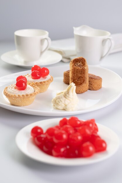 Postre de cerezas dulces con dedos de almendra y dos pasteles de cesta