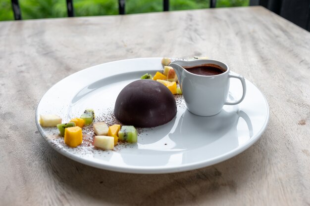 Foto postre de chocolate cacao con rodajas de frutas.