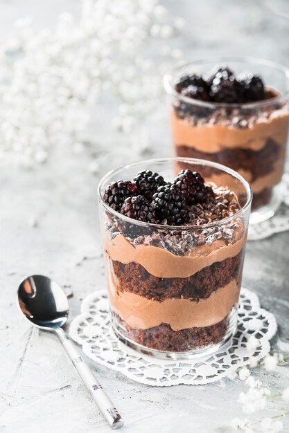 Postre de chocolate en capas en un vaso con moras