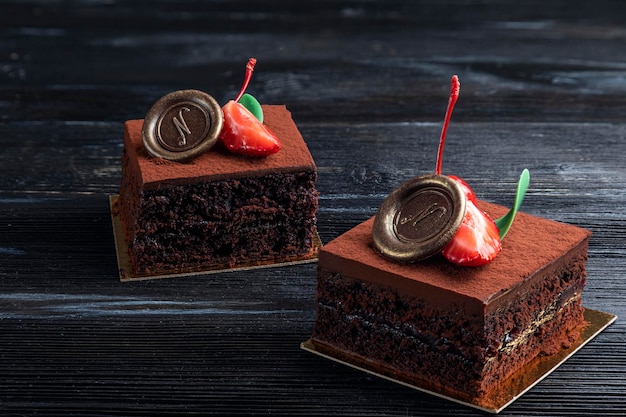 Postre de chocolate decorado con una rodaja de fresa sobre un fondo oscuro