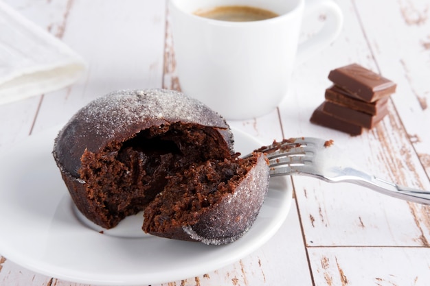 postre de chocolate en un plato con café