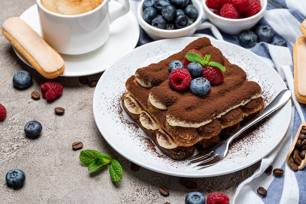 Postre clásico de tiramisú con frambuesas y arándanos