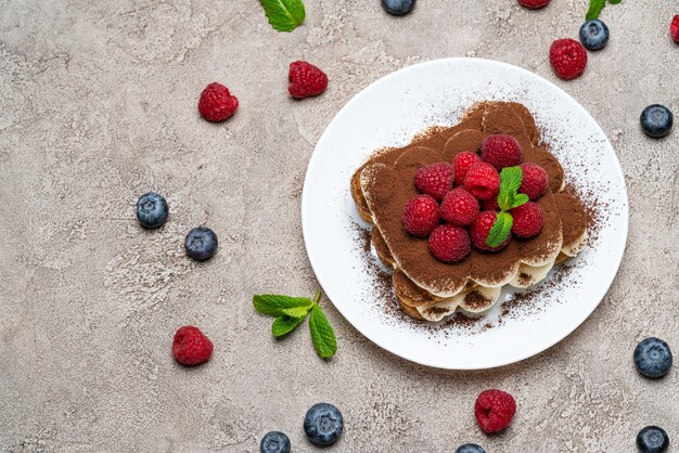 Postre clásico de tiramisú con frambuesas y arándanos