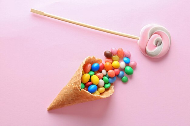 Postre en cono de helado sobre fondo rosa