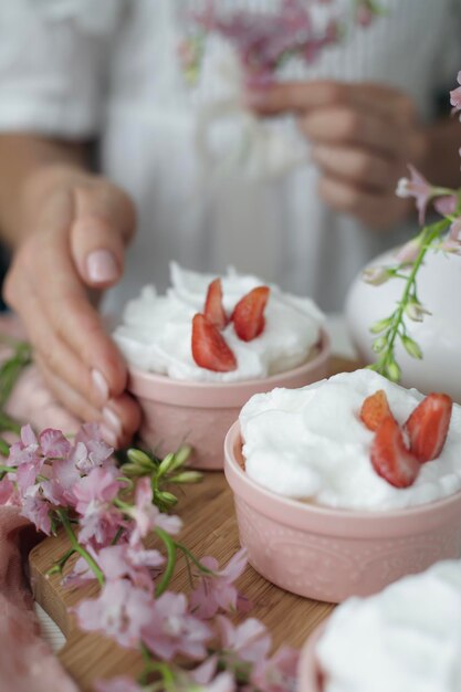 Postre con crema batida y fresas en la mesa chica en el fondo